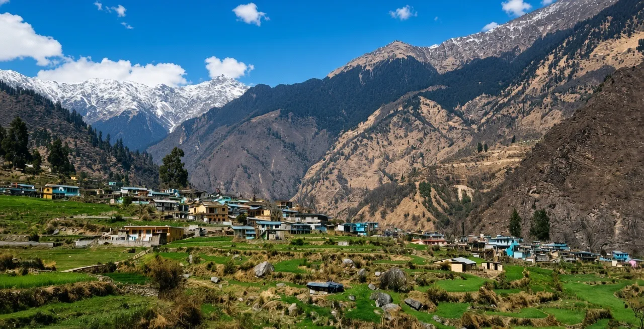 Himalayan village among terraced fields below snow-capped peaks