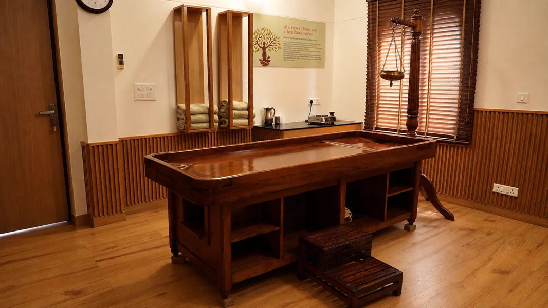 Panchakarma therapy table with Shirodhara stand in the therapy room