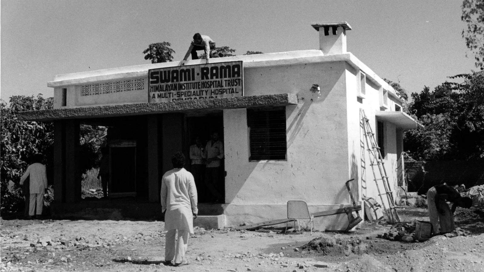 The first Himalayan Institute Hospital Trust building under construction, with its Swami Rama signboard